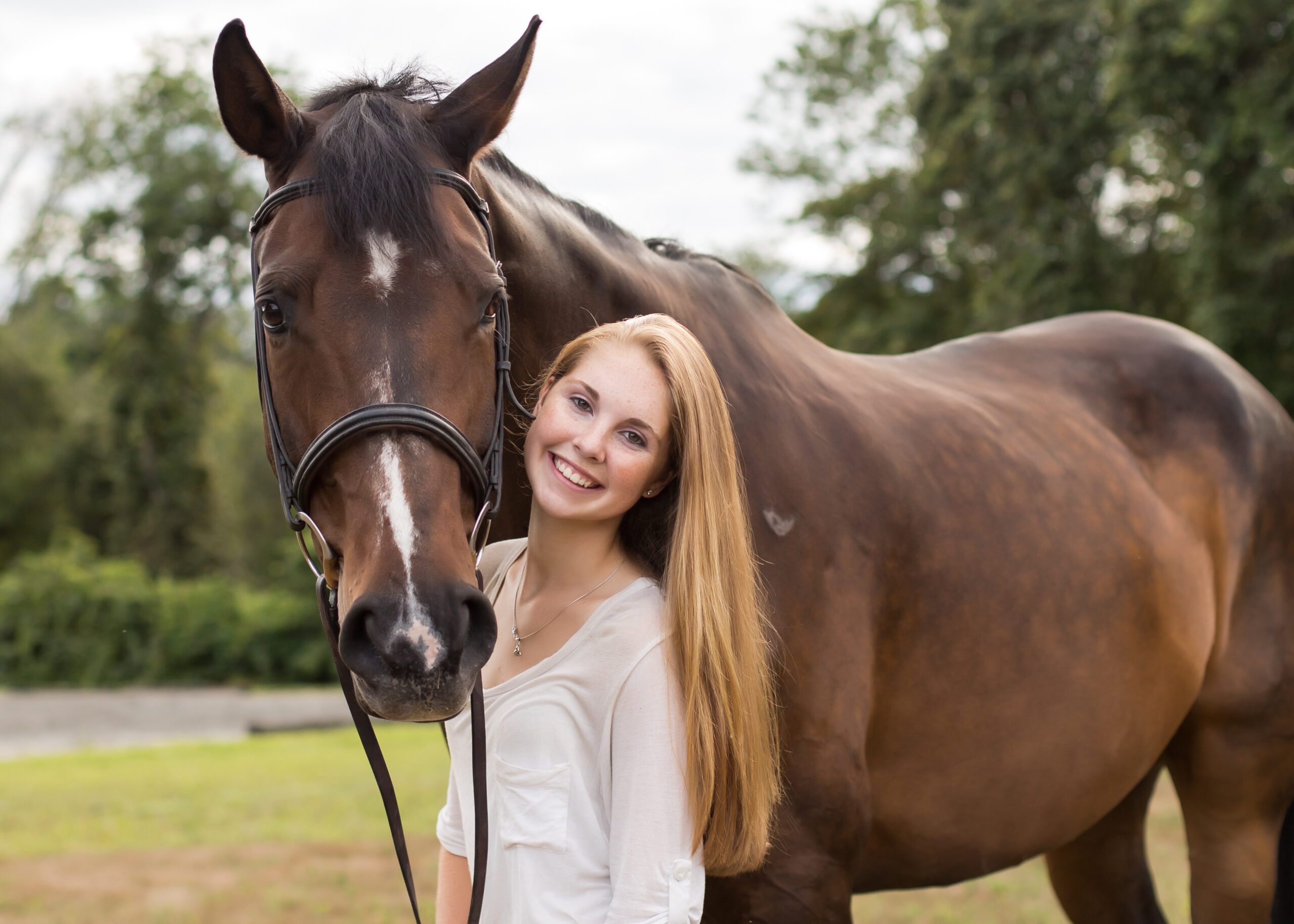 Senior portrait of a young woman with her horse standing in a field in Massachusetts photographed by Sean Wytrwal of J&S Photography